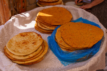 A blue plastic bag is on top of a pile of flatbreads
