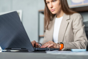 Serious focused businesswoman working in an office with laptop computer