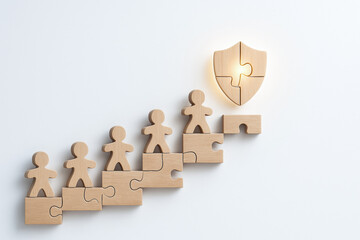 Wooden puzzle figures symbolize life and health insurance protection teamwork and security concept with shield on white background