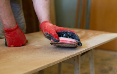 Craftsman Sanding Wooden Surface by Hand in Workshop