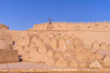 A wall with many arches and a tree in the middle