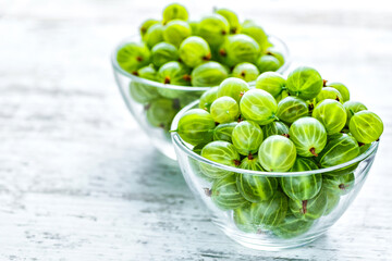 Green Organic Berries Gooseberries.Ripe gooseberry in a glass plate.Gooseberries on the wooden table. Harvest concept. Vegetarian food.