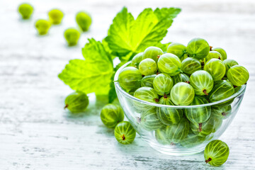 Green Organic Berries Gooseberries.Ripe gooseberry in a glass plate.Gooseberries on the wooden table. Harvest concept. Vegetarian food.