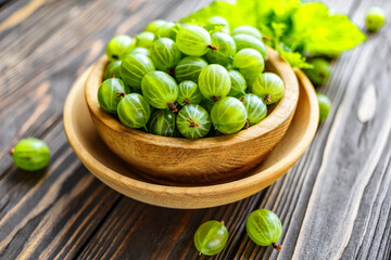 Green Organic Berries Gooseberries.Green gooseberries in a wooden bowl.Gooseberries on the wooden table. Harvest concept. Vegetarian food.