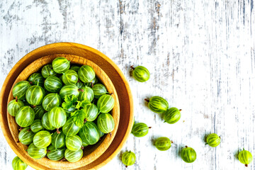 Green Organic Berries Gooseberries.Green gooseberries in a wooden bowl.Gooseberries on the wooden table. Harvest concept. Vegetarian food.