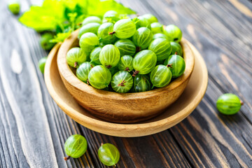 Green Organic Berries Gooseberries.Green gooseberries in a wooden bowl.Gooseberries on the wooden table. Harvest concept. Vegetarian food.