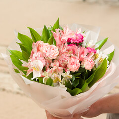 A lovely arrangement of pink and white flowers, delicately wrapped in tissue paper.  The bouquet...