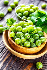 Green Organic Berries Gooseberries.Green gooseberries in a wooden bowl.Gooseberries on the wooden table. Harvest concept. Vegetarian food.