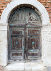 Old arched wooden door with lion knockers
