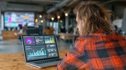 A digital marketer analyzing social media insights on a laptop in a trendy office environment