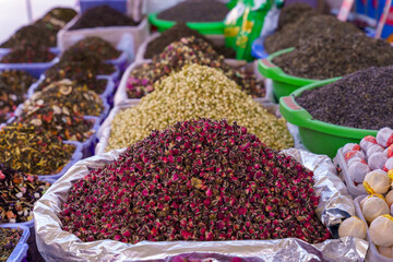A pile of rose petals is on top of a pile of other spices