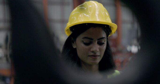 Asian female engineer using machine control tools factory. Modern factory control technology. Safety standards while working Wear helmet. woman workers working professional. Industrial industry