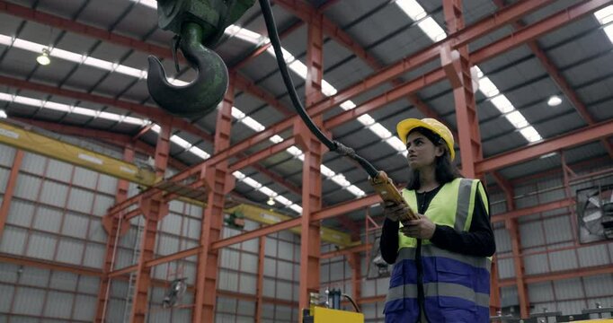 Asian female engineer using machine control tools factory. Modern factory control technology. Safety standards while working Wear helmet. woman workers working professional. Industrial industry
