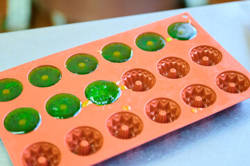 Marmalade pieces setting in colorful silicone mold at a kitchen counter during an afternoon activity