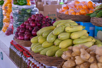 A table full of fruits and vegetables including bananas, squash, and oranges