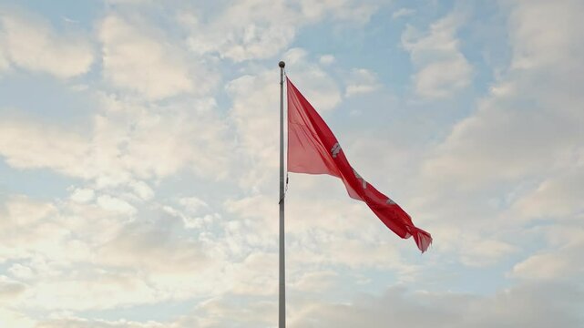 Historical Lithuanian flags, coat of arms of Lithuania, consisting of an armour-clad knight on horseback holding a sword and shield, is also known as Vytis, waving in the wind against blue sky