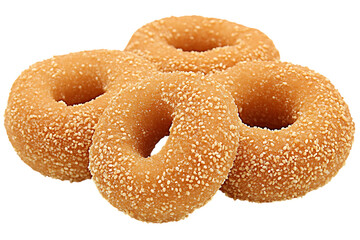 Several sesame donuts are stacked against a transparent background.