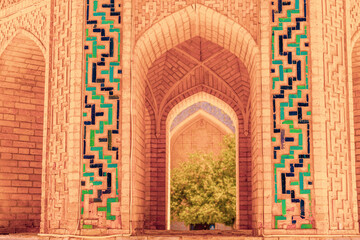 A brick archway with green and blue tiles