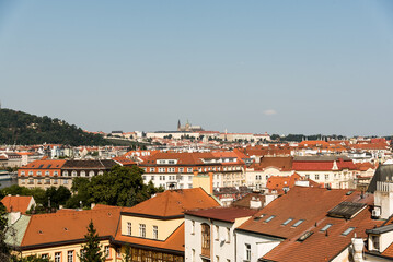 Panoramic view over Prague with orange rooftops and blue sky
