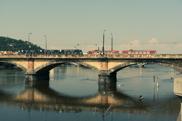 Historic bridge in Prague with red trams
