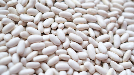 Close-up image of a large pile of white kidney beans, also known as cannellini beans. 