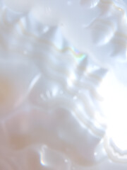Mother of Pearl Texture: Close-up view of a mother-of-pearl surface, showcasing its iridescent and swirling patterns, with varying shades of creamy white and soft beige.