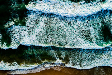 Top view Dark waves crashing on sandy shore beach background,Amazing waves sea nature background