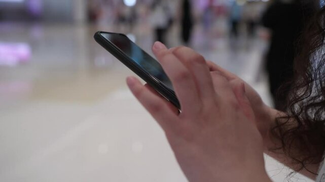 Woman use mobile phone. Close up on person use smartphone in shopping mall. Millennial generation z female scroll through news feed on app on her phone.