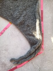 The process of knitting with bamboo wooden needles made of gray mohair yarn. High quality photo