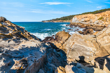 Coastal cliffs along California's Highway 1 in Northern California. Rugged ocean rocks, crashing waves, and a colorful sky create a breathtaking Pacific Coast landscape