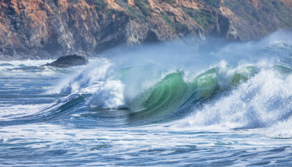 Powerful ocean waves with turquoise and blue hues crash and foam, creating a dynamic and energetic...