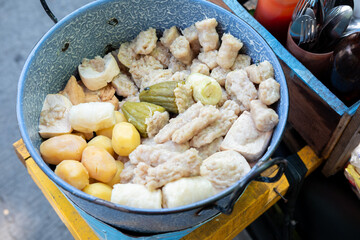 A colorful mix of Siomay, including steamed dumplings, stuffed peppers, potatoes, and tofu, arranged in a blue pot. Popular Indonesian street food.