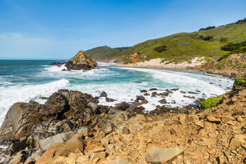 Stunning coastal landscape along California's Highway 1, featuring rugged rocky formations, and the vast blue ocean. A breathtaking natural scene showcasing the raw beauty of the Pacific coastline