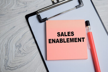 Concept of Sales Enablement write on sticky notes isolated on Wooden Table.