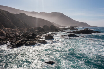 Stunning coastal landscape along California's Highway 1, featuring rugged rocky formations, and the vast blue ocean. A breathtaking natural scene showcasing the raw beauty of the Pacific coastline