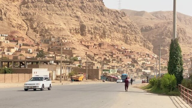 Deserted arid landscape with traditional compound house settlement on valley. Afghanistan Rural countryside village panorama with mountains background