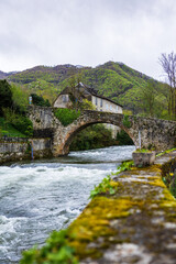 Fototapeta premium Bridge crossing the Lez River in the hamlet of Ourjout in the village of Les Bordes-sur-Lez in the Couserans region of Ariège