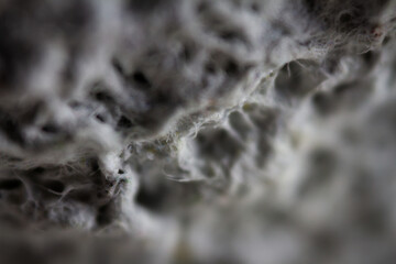 Extreme close up of old gray handmade paper clay with a structure and rough texture. Paper recycling. Selective soft focus, shallow depth of field.