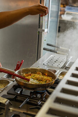 Spaghetti Dish with Shrimp Being Cooked on Stove