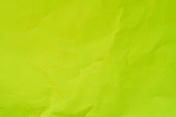 Textured light green color crumpled paper background.