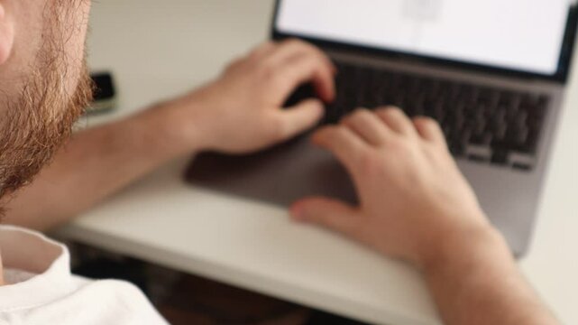 The guy points the trackpad at an error in the text and erases it with the keyboard