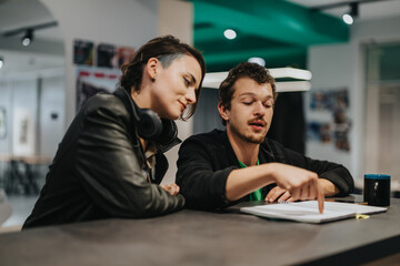 Two coworkers engaged in a constructive discussion while reviewing documents in an office environment, exuding professionalism, productivity, and teamwork dynamics in a modern professional setting.