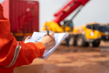 An engineer or foreman is checking on safety checklist form of lifting crane at the drilling rig...