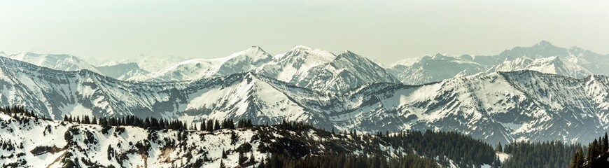 Obraz premium View of the Alpine foothills from Wallberg Mountain Mountains on the horizon in the morning mist. Mountain range on the horizon in the morning mist.panoramic photo 