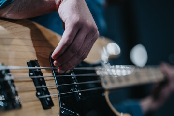 Close-up of musician playing bass guitar during a practice session