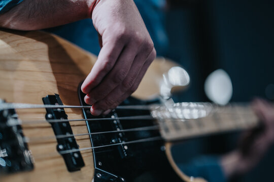 Close-up of musician playing bass guitar during a practice session