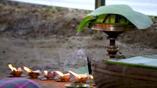 Composite shot of burning earthen lamp or saki and incense sticks with assamese sarai close up