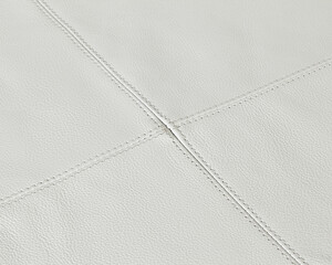 White leather texture background showing stitching detail on upholstery
