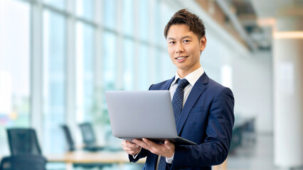 ノートパソコンを持つ笑顔のビジネスマン