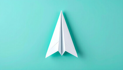 Fototapeta premium Paper Airplane on Turquoise Background: Creativity, Inspiration, and Success Concept